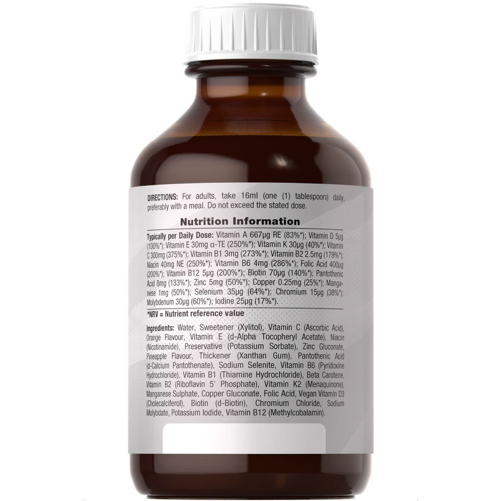 Hand holding a 480ml bottle of HU Multivitamin Vegan Liquid.