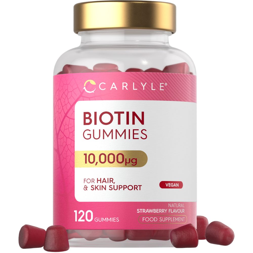 Red Biotin Gummies 10,000µg, with several gummies spilled from a clear bottle, displayed on a hand scale.