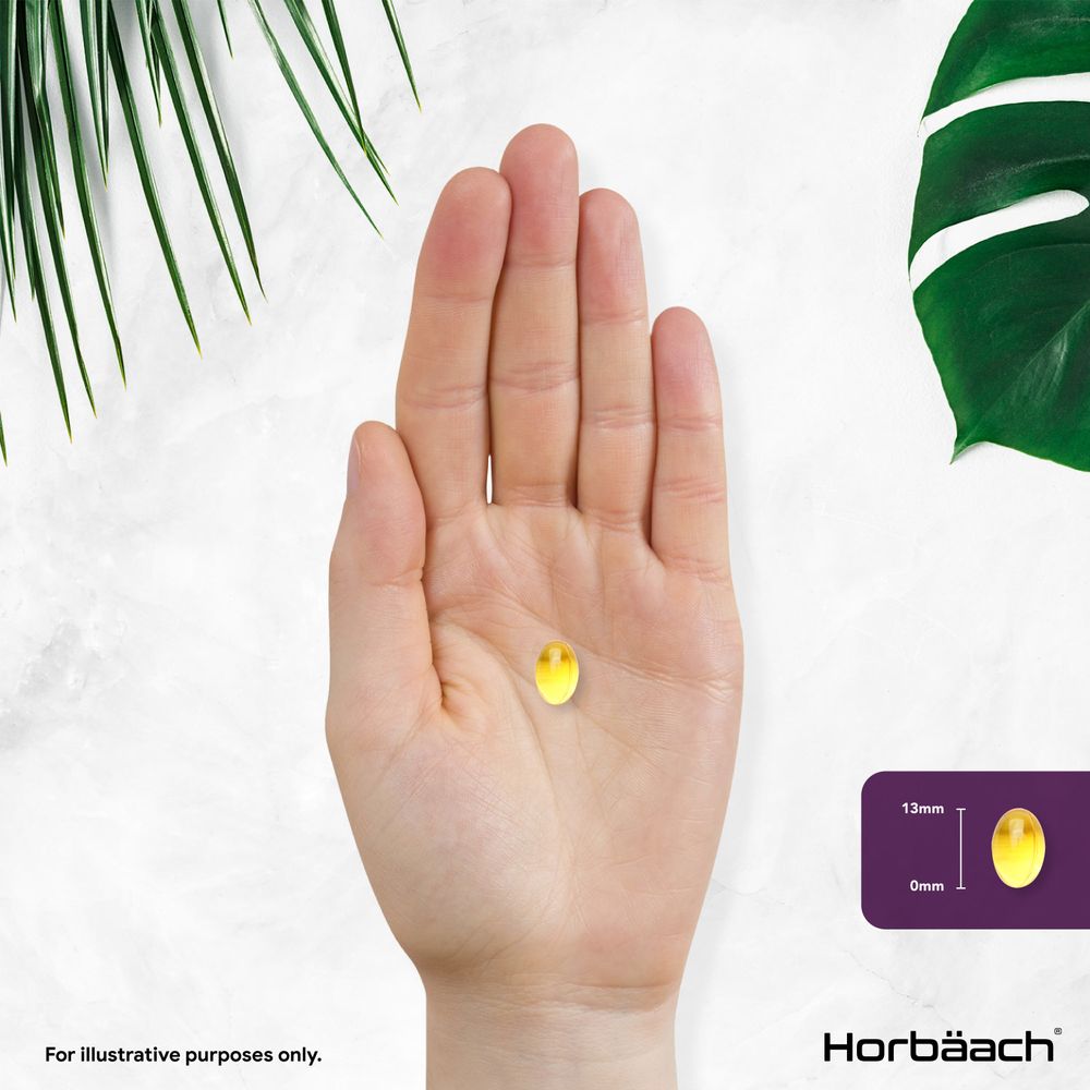 A yellow softgel held in a hand, with an inset showing the softgel measuring 13mm long. It appears 0mm wide.