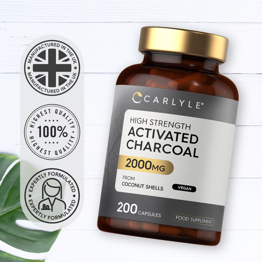 Hand holding a bottle labeled Activated Charcoal 2000mg with 200 capsules.