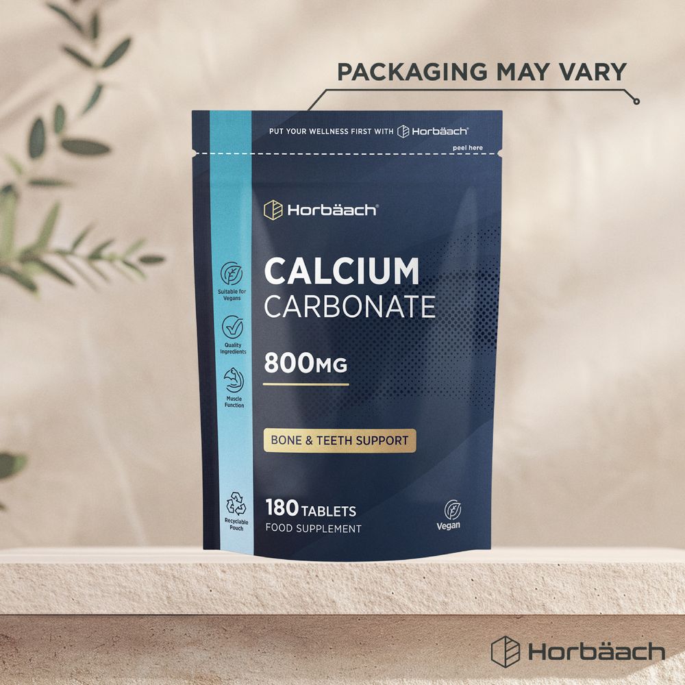 180 tablets of Calcium Carbonate, each at 800mg, displayed on a hand scale, illustrating bulk weight.
