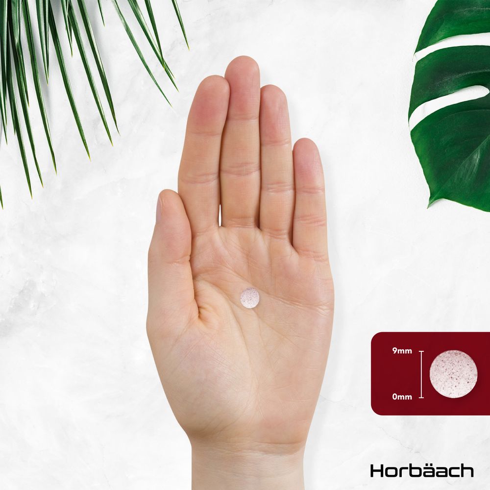 A tablet measuring 9mm in diameter and 0mm thick is resting on an open palm.
