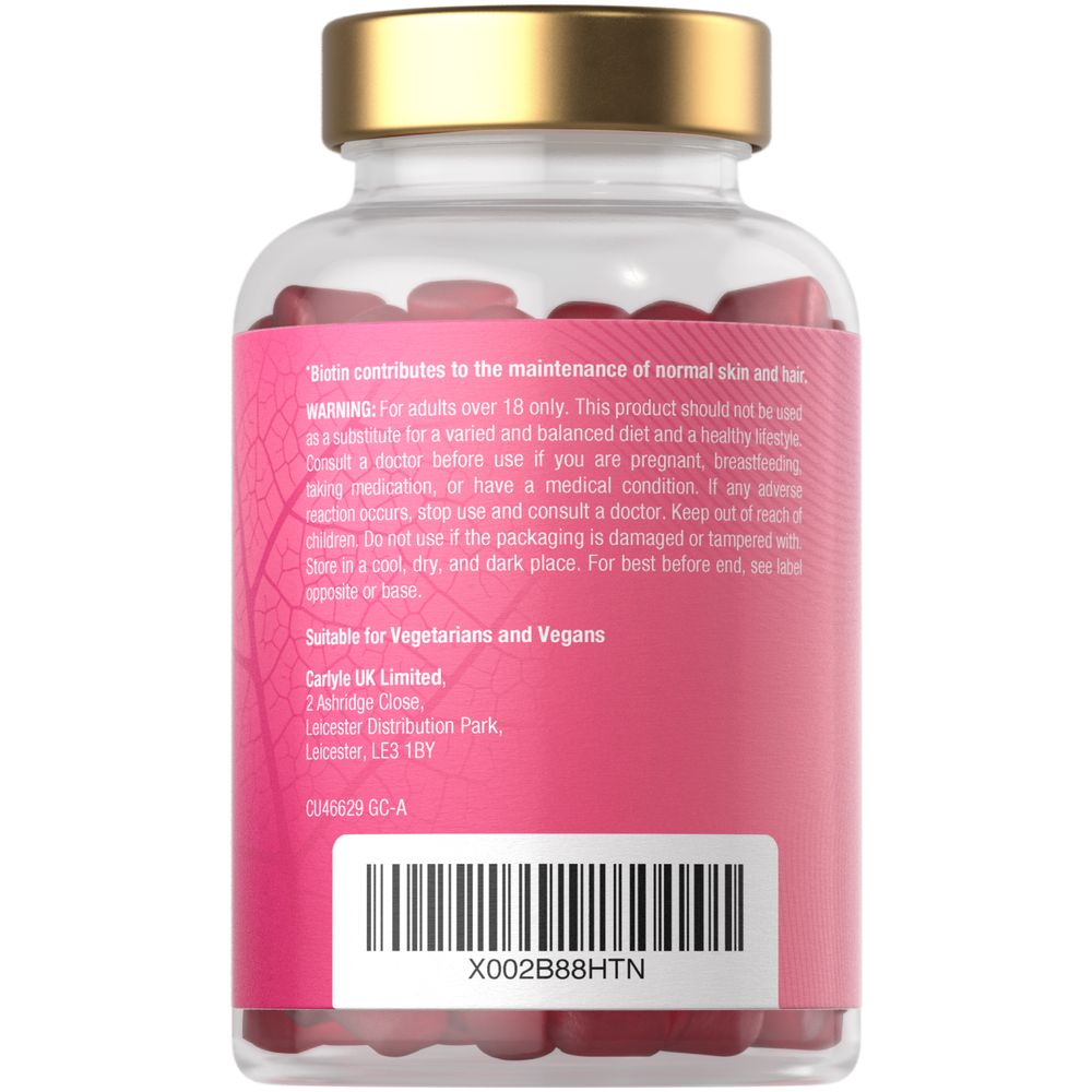 A clear bottle containing red Biotin 10000ug vegan gummies, displayed on a scale.