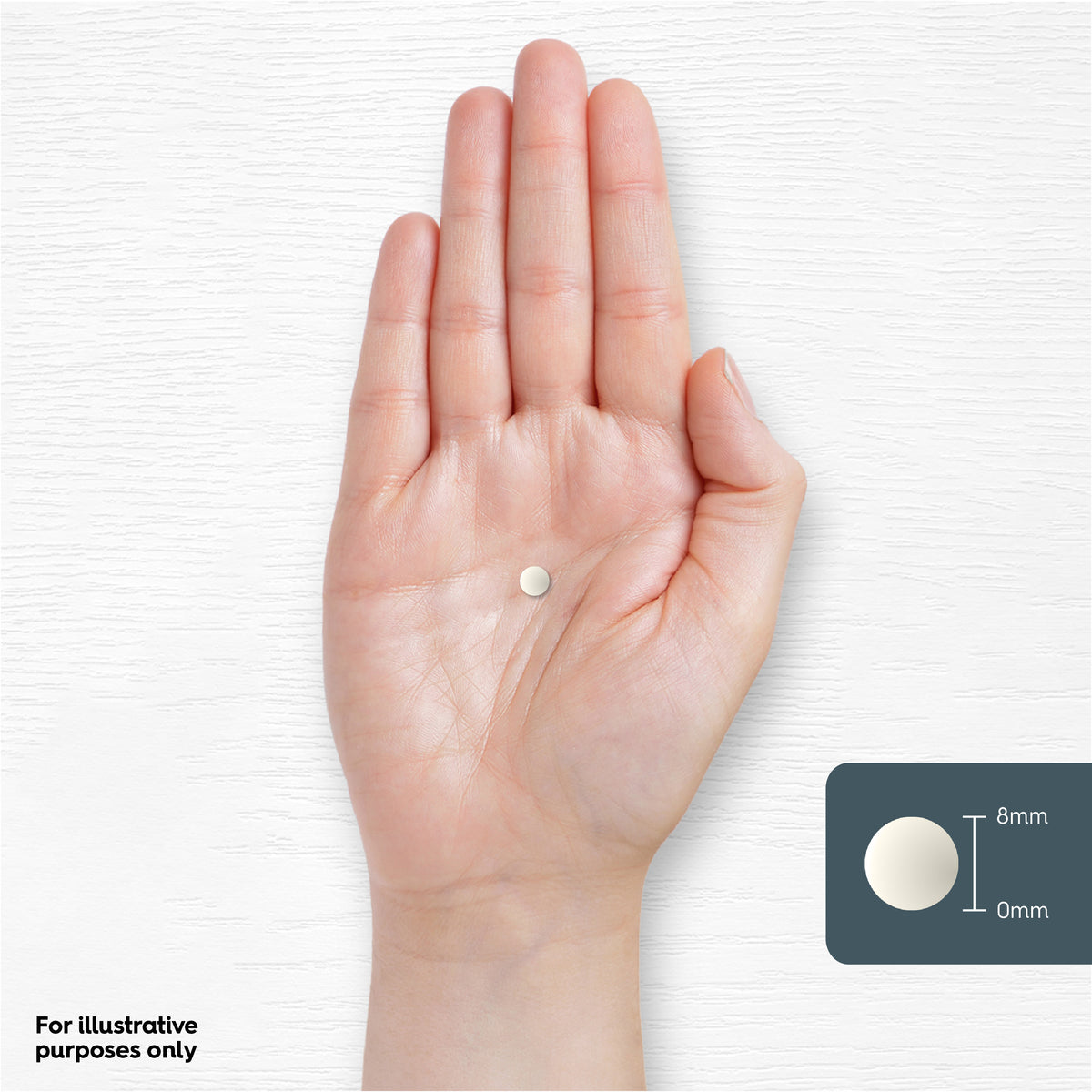 A single white 8mm tablet rests on a person's hand.