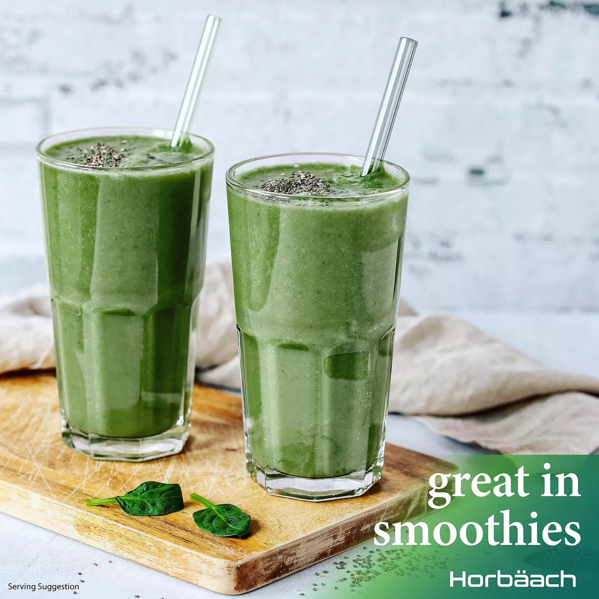 Two green smoothies with chia seeds and straws sit on a wooden board with spinach leaves. Text: great in smoothies.